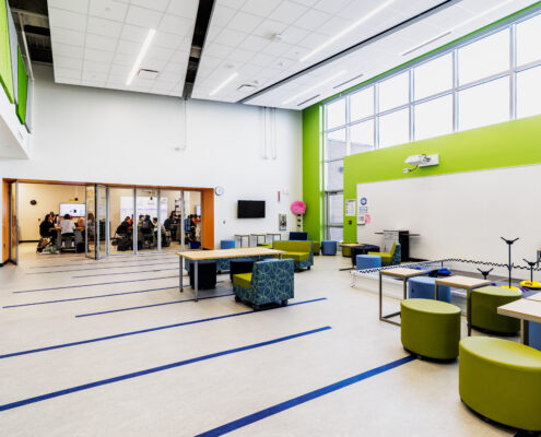 Learning Hub Space for Students to Collaborate or Conduct Experiments from their Adjacent Lab Classroom (i.e., robotics in the back right of the photo)